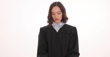 Kadın yargıç elleri kelepçeli beyaz arka planda tokmak tutuyor. Hukuk hizmetlerini iyileştirmek için adli sistemdeki suçların soruşturulması