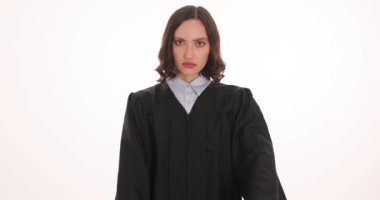 Yargıç tokmağı beyaz arka planda durdurma hareketi sergiliyor. Kadın yargıç yasal bağlamda otorite ve karar verme yetkisini temsil ediyor