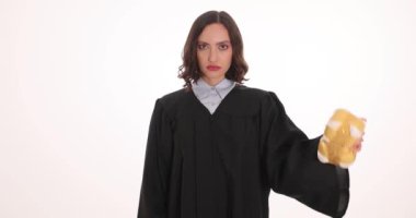 Kadın yargıç beyaz arka planda kelepçe ve narkotik çantası tutuyor. Kadın memur uyuşturucu kaçakçılığından yasal ceza uyguladı