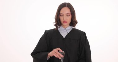 Siyah elbiseli kadın avukat beyaz arka planda kum saati tutuyor. Kadın yargıç, zaman hukuku ve adaletini profesyonel ortamda yavaş çekimde gösterdi