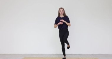 Genç kadın modern stüdyoda enerjik dans adımları uyguluyor. Yetenekli kadın performans için koreografiyi geliştirme çalışmalarına katılıyor