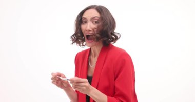 Esmer kadın hamilelik testi pozitif çıktıktan sonra neşe saçıyor. Kadın, gelecekteki anneliğin heyecanını beyaz ağır çekimde gösterir.