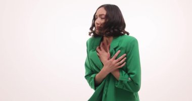 Yeşil ceketli iş kadını beyaz arka planda şok ve korku yaşıyor. Stresli esmer genç kadın sorunlara duygusal tepki veriyor.