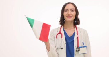 Üniformalı kadın doktor beyaz arka planda İtalyan bayrağı sallıyor. Steteskoplu esmer doktor, ülkeyi yavaş çekimde ziyaret etmek istediğini gösteriyor.