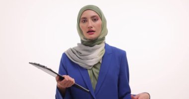 Müslüman iş kadını, iş tartışması belgeleriyle ayakta duruyor. Türbanlı kadın girişimci, jestler kullanarak bilgileri özgüvenle sunar