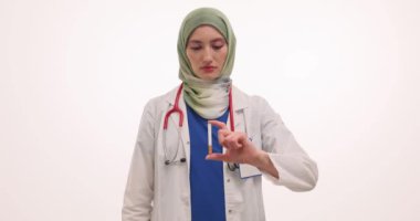Müslüman kadın doktor elinde sigara tutmaktan vazgeçtiğini söylüyor. Türbanlı kadın doktor sigara içmeyi yasakladı. Beyaz duvara karşı tehlike empati kuruyor.