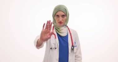 Müslüman kadın doktor, CBD yağını artırırken dikkat gösteriyor. Başörtülü kadın hekim elinde marihuana yağını narkotik olarak gösteren dur işareti yaptı