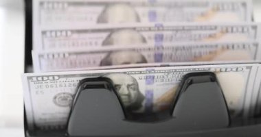 Banknota sayacı, banknotların banknotlarını banka bürosundaki masaya yığar. Para transferlerini hatasız halletmek için gerekli ekipman