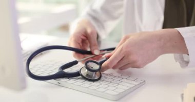 Profesyonel kadın hekim kapsamlı incelemeyi tamamladı. Deneyimli aile doktoru kontrolün sonunda steteskobu masa sinyallerine yerleştiriyor.