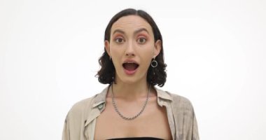 Genç bir kadın kaşlarını kaldırır ve ağzını yavaşça açar. Şık esmer kadın, olayların ani gelişmesinden hayret ediyor. Yavaş çekim.