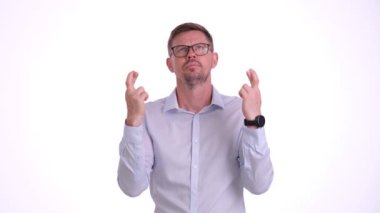 Ofis kıyafetleri içindeki sakallı adam dua ederken parmaklarını çapraz yapar. Gergin adam dudaklarını kaldırır ve yalvarma kelimelerini söyler.