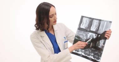 Kadın doktor sonuçları açıklayan radyografik görüntüye işaret ediyor. Kadın doktor hesaplanmış tomografiyi inceler. Değerlendirme detaylarını taramak için kalemle işaret eder.