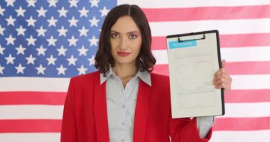 Güzel bir Amerikan bayrağının arka planında gururla duran kendine güvenen bir şahıs.