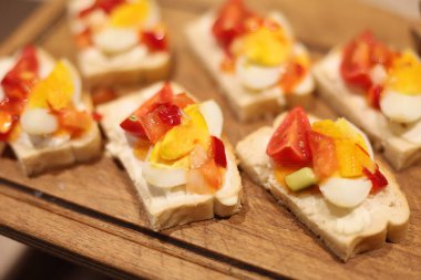 Bu canlı ve renkli aperatifler taze ekmek dilimlerinin üzerinde doğranmış sebze ve yumurtaların enfes bir karışımını içeriyor.