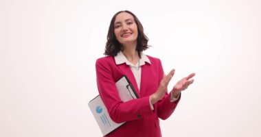 Gülümseyen iş kadını el çırpıyor. Kolunun altında pano tutuyor. Kadın çalışan, başarılı proje sunumuyla takım arkadaşlarını tebrik ediyor