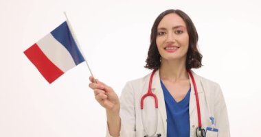 Tıp üniformalı genç bayan doktor Fransız bayrağı sallıyor. Kadın hekim, tıp konferansında yavaş çekim için ülkeyi ziyaret etme heyecanı gösteriyor