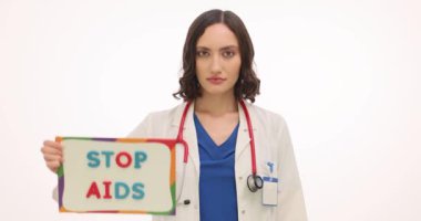 Kadın doktor, AIDS 'in prezervatif tutmasını engelleyen kelimelerle işaret veriyor. Kadın doktor, beyaz arka planda yavaş çekimde HIV 'i önlemek için korumayı teşvik ediyor