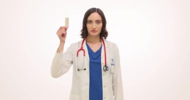 Esmer kadın doktor oral doğum kontrol hapları ve prezervatif gösteriyor. Tıbbi üniformalı kadın jinekolog doğum kontrol yöntemlerini sunar.