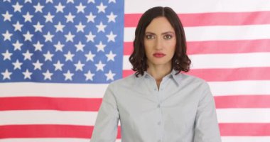 Ciddi genç kadın Save Planet tabelasını Amerikan bayrağına karşı gösteriyor. Güvenilir esmer kadın çevre koruma kampanyası yürütüyor.