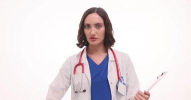 Kadın doktor, beyaz arka planda mide ağrısının ortak nedenlerini açıklıyor. Doktor, randevuda mide rahatsızlığına yol açan alışkanlıklardan bahsediyor.