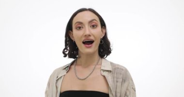 İlham dolu genç bir kadın beyaz arka planda el çırpmaktan memnun olduğunu ifade ediyor. Gülümseyen esmer kadın, minnettarlığı alkışlarla yansıtır.