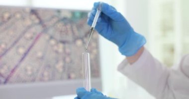 Kimyager, pipetle reaktörü laboratuarda yapılan testlere koyar. Bilimadamı tıbbi laboratuvarda incelemeler için çözümü dikkatlice hazırlıyor