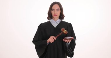 Ciddi kadın yargıç tokmağı çaktı ve kararı açıkladı. Siyah elbiseli kendinden emin kadın, beyaz arka planda karar açıklamasıyla duruşmasını bitirdi.