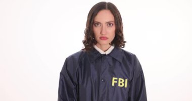 Üzgün FBI ajanı, elleri kelepçeli bir şekilde beyaz arka planda dolarları tutuyor. Hükümet ajanının rüşvet ve yasadışı güç kullanımından tutuklanması
