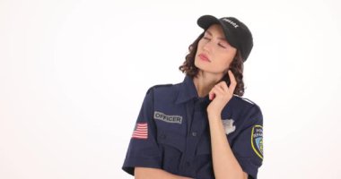 Düşünceli kadın polis, suç davasını beyaz arka planda analiz ediyor. Polis memuru yavaş çekimde şüphe uyandıran ipuçları arıyor.