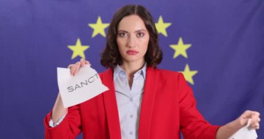 Siyasetçi kadın, AB bayrağına karşı duran sözlerle kağıt yırtıyor. Esmer kadın Avrupa 'daki mevcut siyasi sorunları protesto etti
