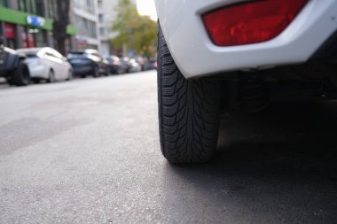 Yoğun bir şehir caddesinde, şehir hayatının ve ulaşımın özünü gözler önüne seren bir araba lastiğinin yakın çekimi.