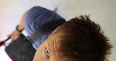 Deneyimli bir tamirci kırık ampulü çıkarmak için merdivenleri tırmanır. Adam merdivenin en üst basamağında dengede durur.