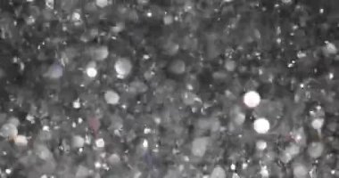 Gümüş pullar partinin atmosferini oluşturan ışığı yakalıyor. Konfetiden gelen holografik ışıltılı arka plan. Kutlama konsepti