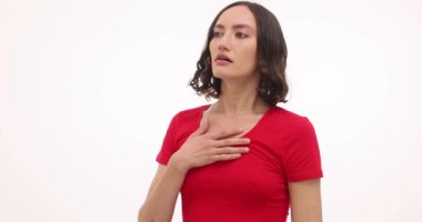Solunum problemleri olan esmer bir kadın göğsünü tutuyor ve avuçlarını beyaz arka planda tutuyor. Kırmızı tişörtlü genç bir kadın hastalık saldırısından boğuldu.