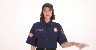 Kadın polis memuru bir yığın dolar ve kelepçe tutarak el kaldırıyor. Genç bayan polis, rüşvet soruşturması sırasında ele geçirilen parayı gösteriyor.