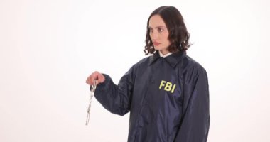 Önlüklü genç kadın FBI ajanı elleri kelepçeli. Kadın federal memur, suç soruşturması sırasında uyum sağladığından şüpheleniliyor.