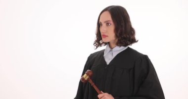 Kararlı yargıç beyaz arka planda tokmağı tutan kelepçelerle elini kaldırıyor. Kadın mahkeme çalışanı suç eylemlerinden tutuklama kararı verdi