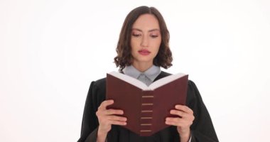 Siyah önlüklü yargıç anayasayı beyaz zeminde okudu. Kadın yargıç karar verebilmek için hukuk okumaya odaklanmış.