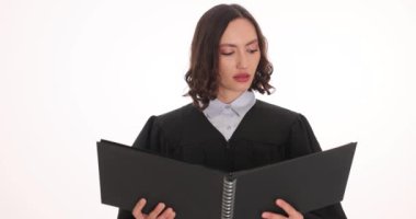 Kadın yargıç beyaz arka planda halka klasörünün yasal hükmünü okudu. Kadın çalışan, mahkeme kararını açıkladı.