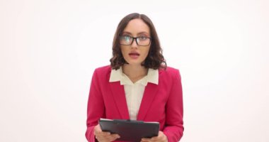 Kadın yöneticiler detaylı raporları okurlar ve beyaz arka planda şaşkınlık içinde kaşlarını kaldırırlar. İş kadını şok edici detayları ağır çekimde işliyor