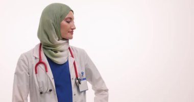 Beyaz arka planda dikkat çekmek için tesettürlü kadın doktor parmaklarıyla işaret ediyor. Müslüman kadın terapist, bilgiyi jestlerle gerçekleştirir