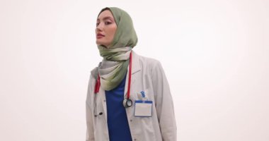 Müslüman kadın doktor etrafa büyüteçle bakıyor. Türbanlı kadın doktor, tıbbi pratikteki detaylara dikkat etmenin önemini vurguladı