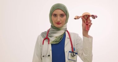 Müslüman kadın doktor rahim modeli ve adet pedi gösteriyor. Kadın hekim regl döneminde hijyenin korunmasının önemini vurguladı