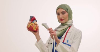 Müslüman kadın doktor, insan kalbi modeline ultrason cihazı uyguluyor. Türbanlı kadın hekim öğrencilere ekokardiyografi eğitimi veriyor