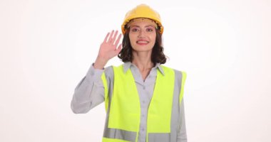 Yansıtıcı yelek dalgasındaki kadın mühendis. Sert şapkalı kadın profesyonel inşaat alanına gelen ziyaretçileri ağırdan alıyor