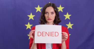 Kadın, Avrupa Birliği bayrağına karşı SCHENGEN VISA ve DENIED yazılı kartları gösteriyor. Esmer kadın tezgahtar başvuru reddediliyor.