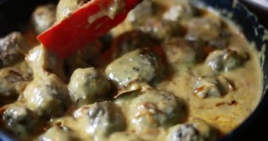 Bu ağız sulandıran lezzetli köfteler bol bol kremalı sosla kaplanarak akşam yemeği için mükemmel hale getiriliyor.