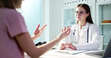 Bir doktor, klinik bir sağlık ortamında önemli bir konsültasyon sırasında hastayı dikkatle dinliyor.