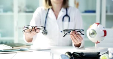 Eğitimli bir profesyonel, etkili görme düzeltmesi için en uygun gözlüğü seçmede müşterilere yardımcı olur