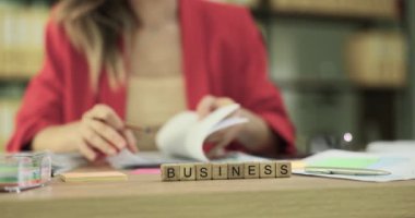 Profesyonel bir kadın, çağdaş ofis ortamında iş belgelerini incelemeye özen gösterir.